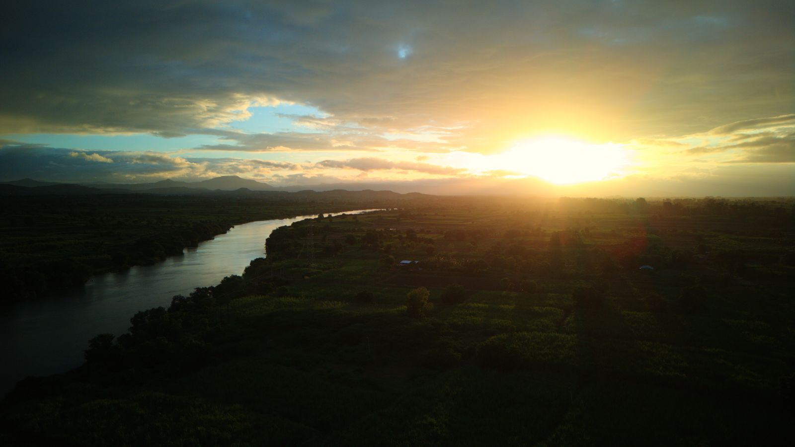 Drone view of the Nira river winding through the farm fields at sunset